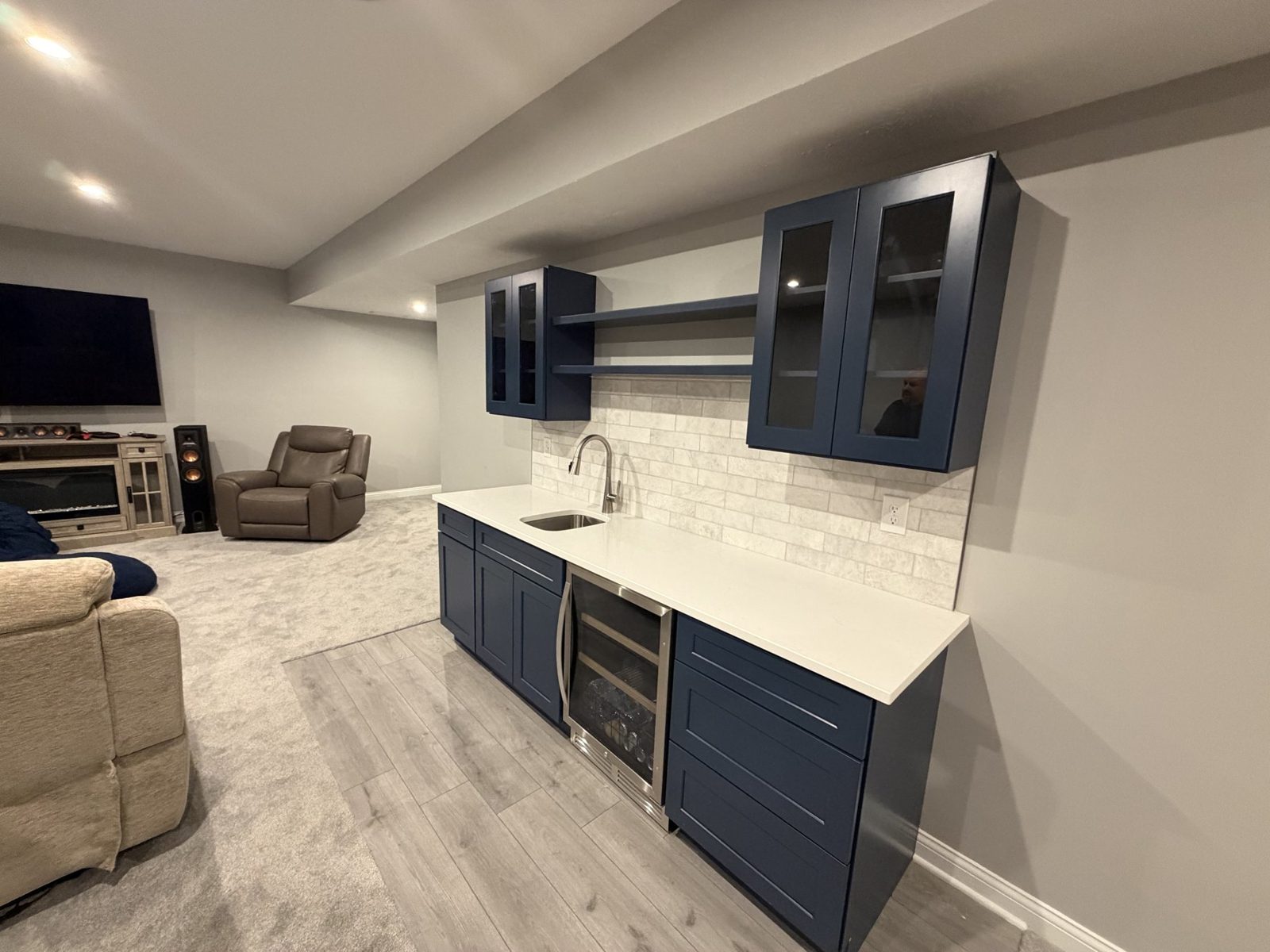 Basement bar with navy cabinets and a white subway backsplash