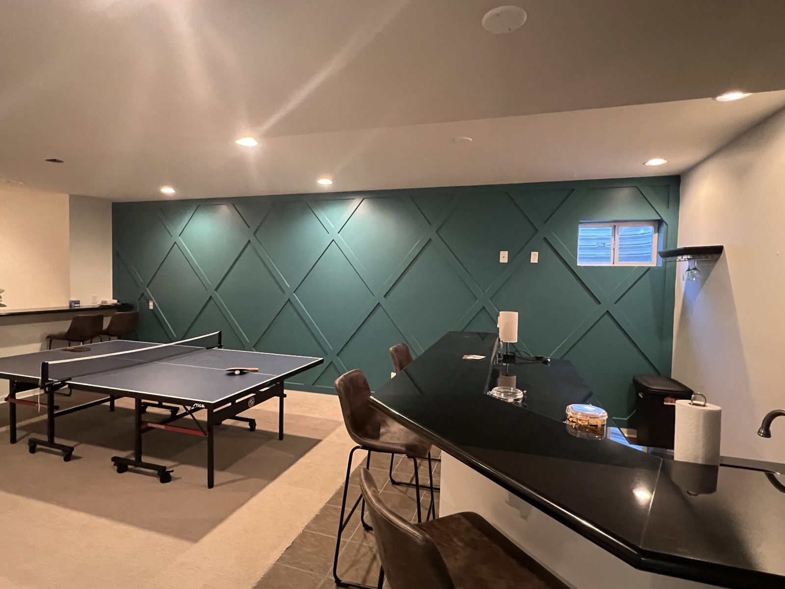 Basement with a green geometric trim wall and a ping pong table