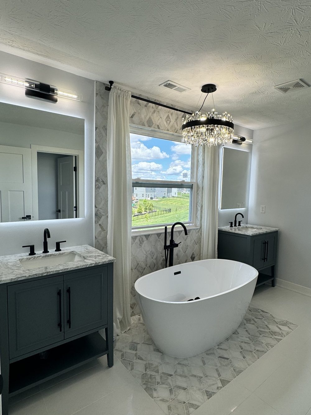 Freestanding tub between two vanities in a finished bathroom