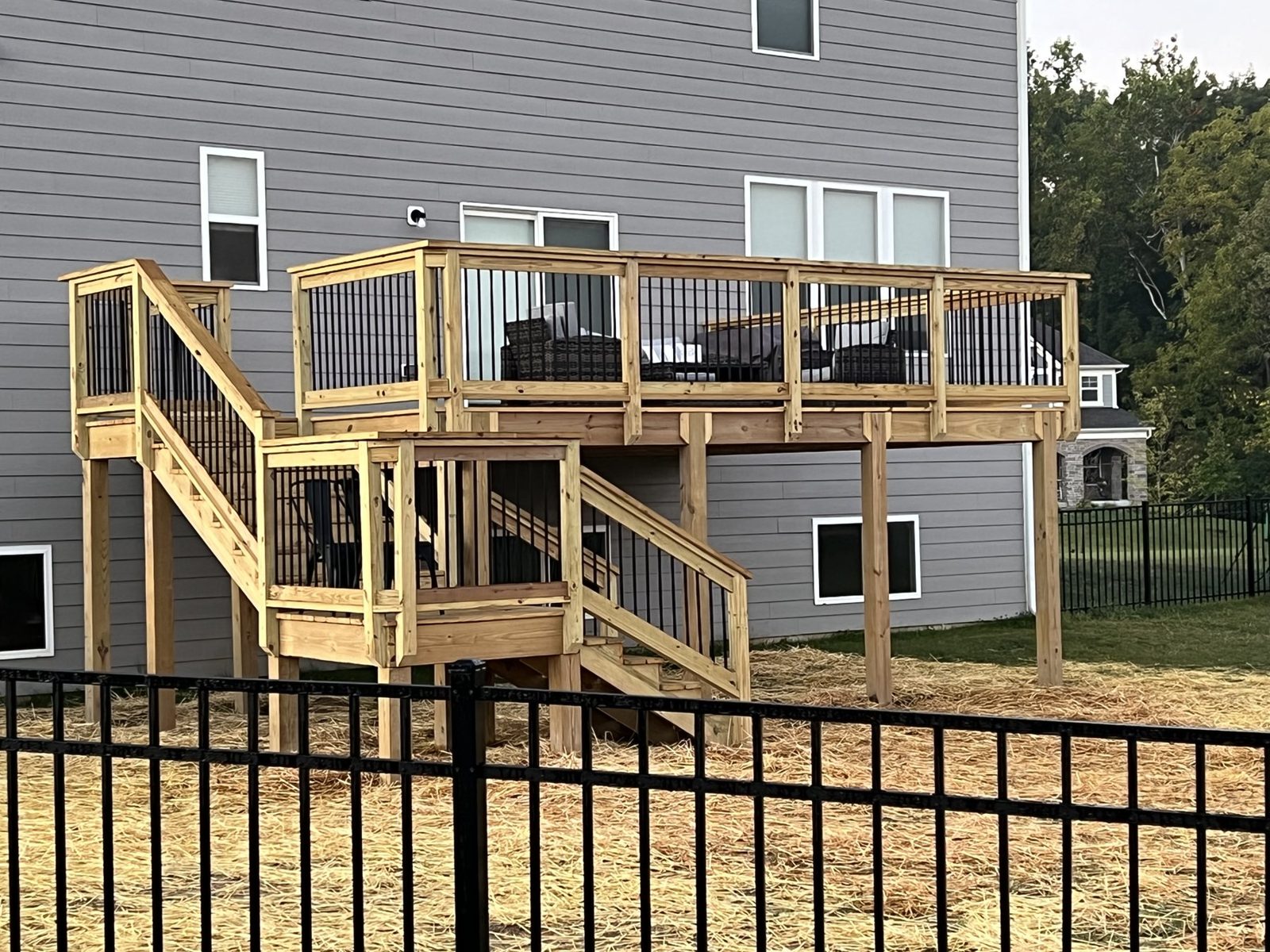 Two level wood deck with railings and stairs on the back of a home