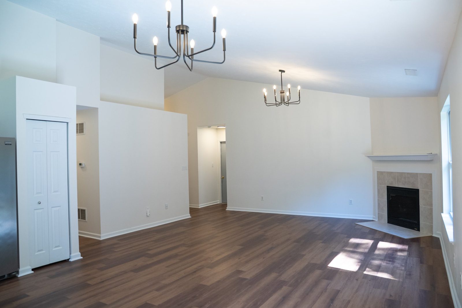 Freshly painted room with a fireplace and new wood flooring