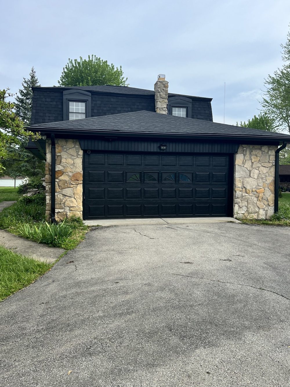 Home exterior after painting in a deep navy with stone accents