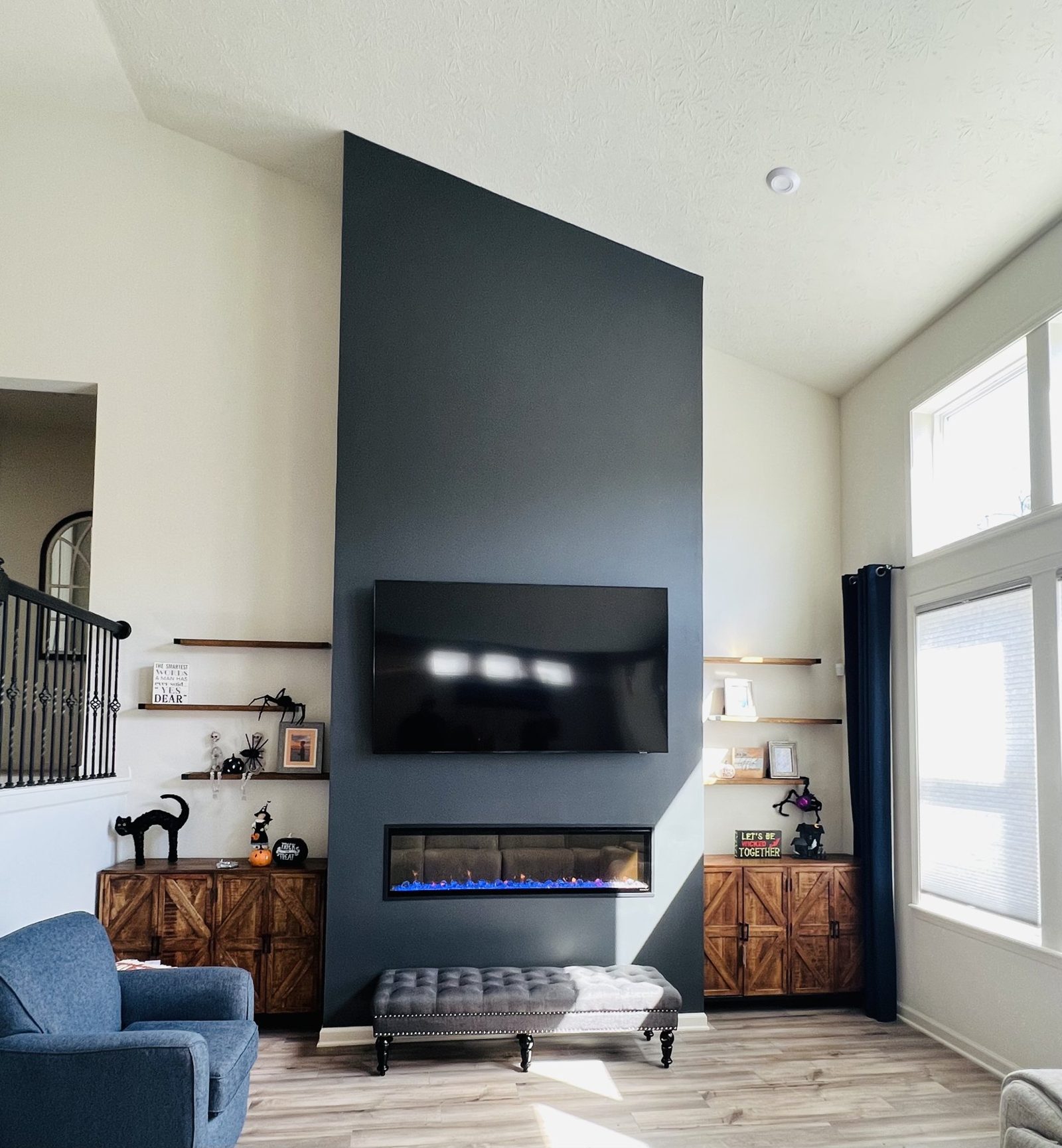 Two story fireplace with a dark surround and a mounted television