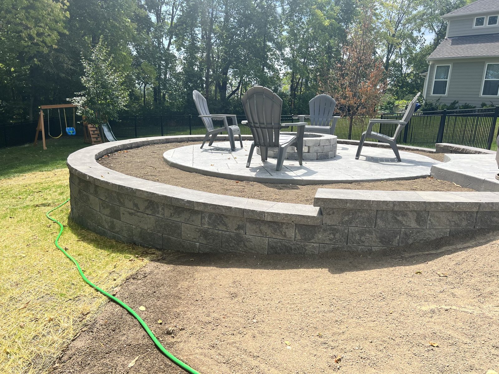 Sitting wall being laid on a new stamped patio before backfill