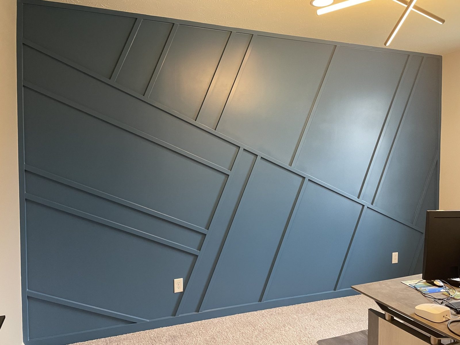 Blue green geometric trim wall built and painted in a living space