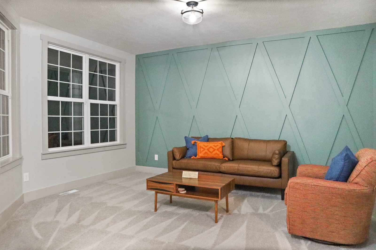 Teal geometric trim wall behind a leather sofa
