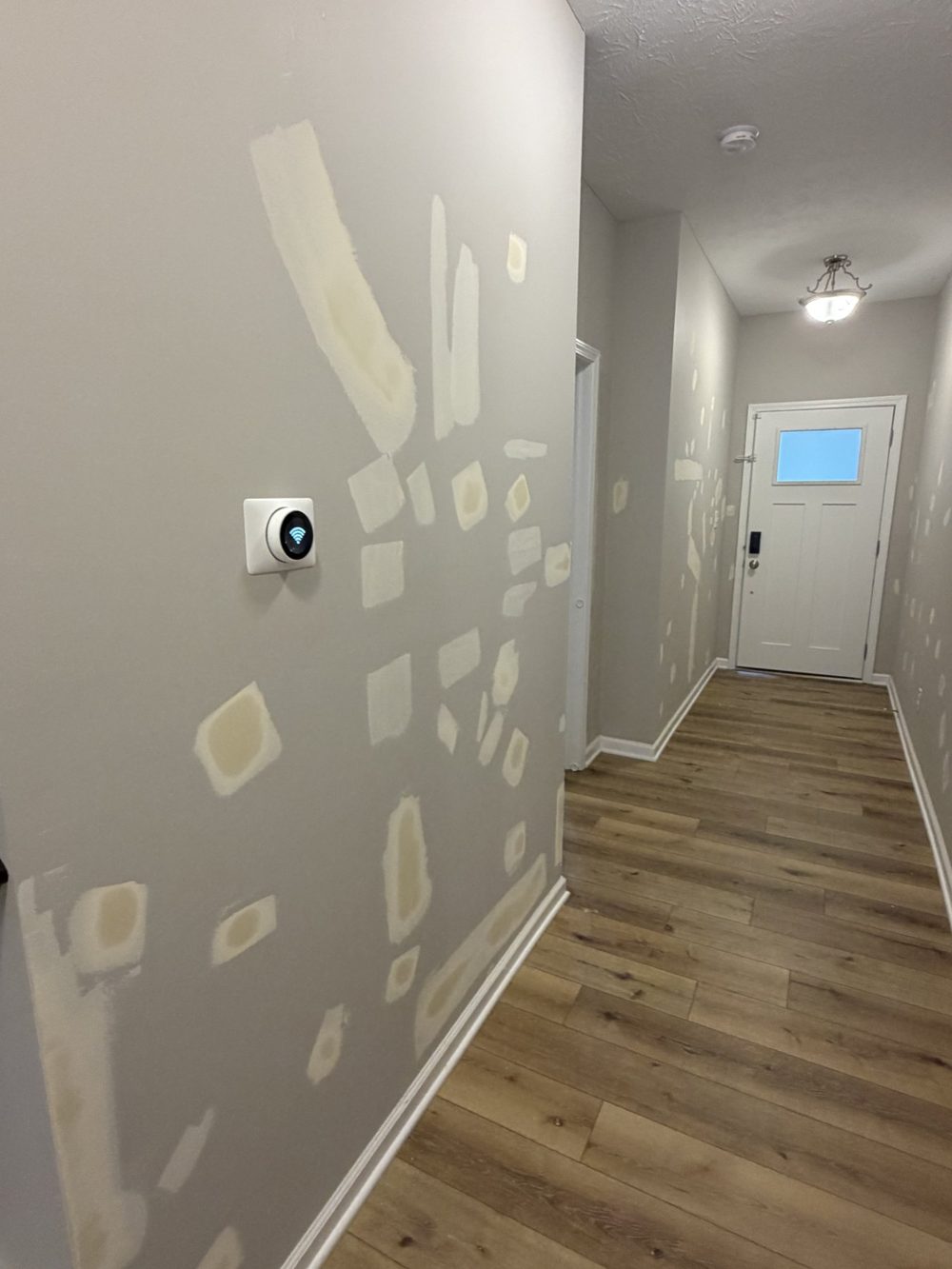Hallway wall with drywall patches sanded and ready for paint